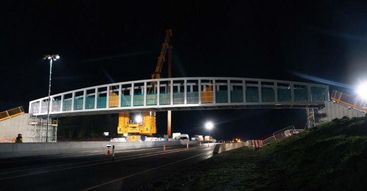 Image shows a steel bridge above a road