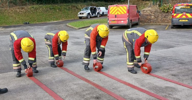 The team wear firefighting uniforms as they practise hose running