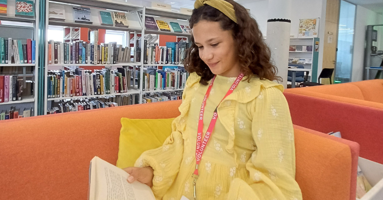 A girl reads a book in a library