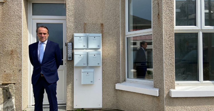 Councillor Olly Monk stands in front of a house