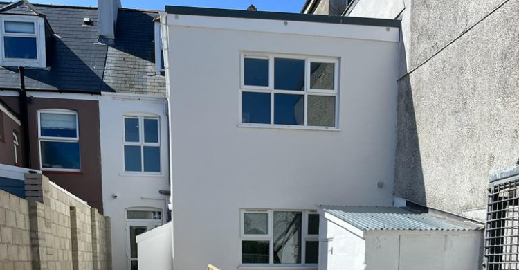 Rear view of a house with windows and an outbuilding