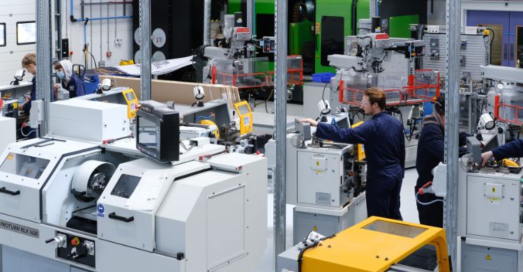 People in an engineering workshop containing several machines