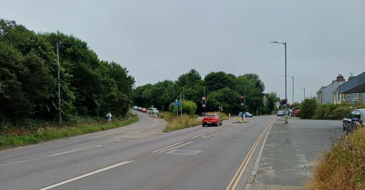 Image shows a road with cars