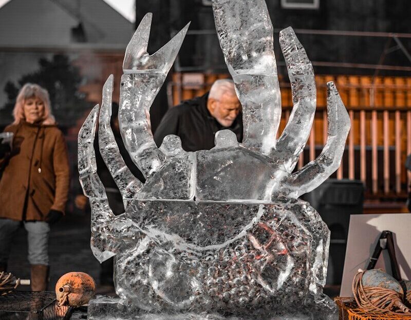 Man examines large ice sculpture of a crab