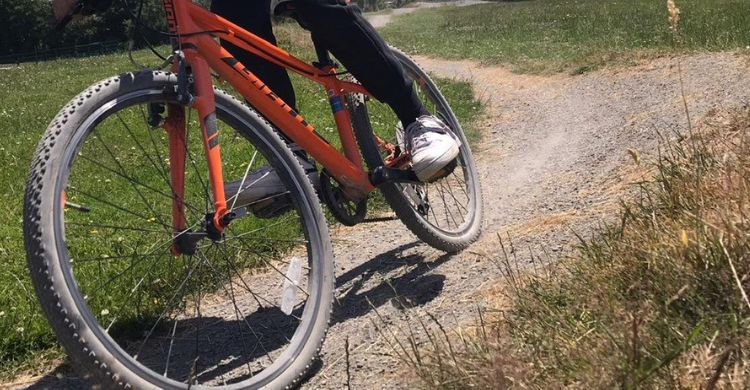 Close up image of a person riding a mountain bike on a cycle track