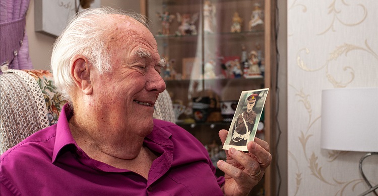 Image of a man looking at a photograph and smiling