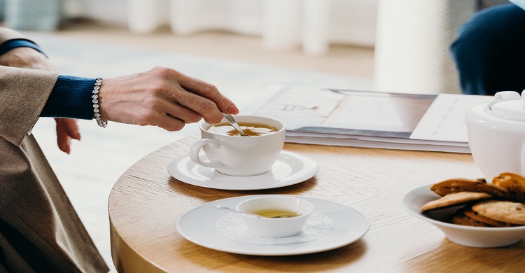 Image of someone stirring coffee
