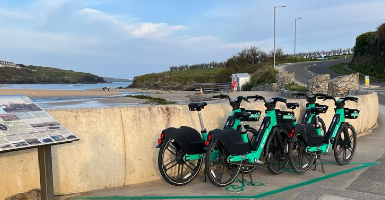 A group of e-bikes in a bay next to a beach