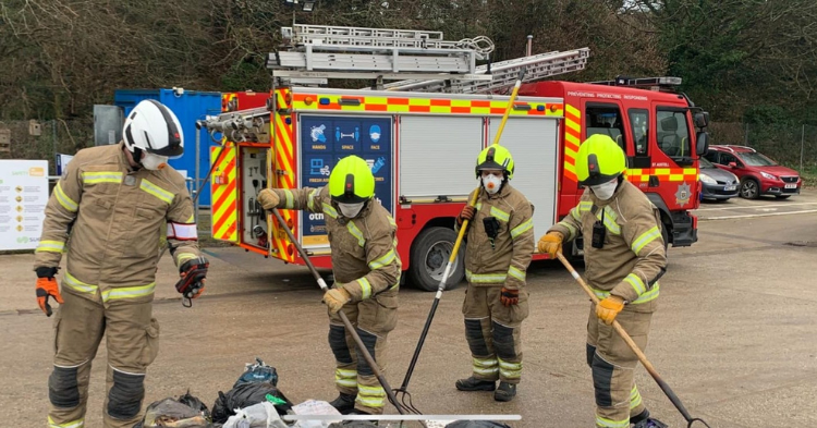 Firefighters sift through rubbish following a suspected battery fire