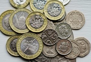 a pile of british coins sitting on top of a table