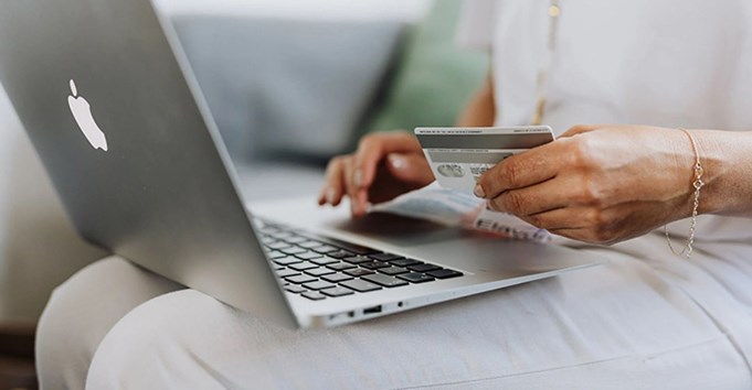 Person entering bank details on laptop